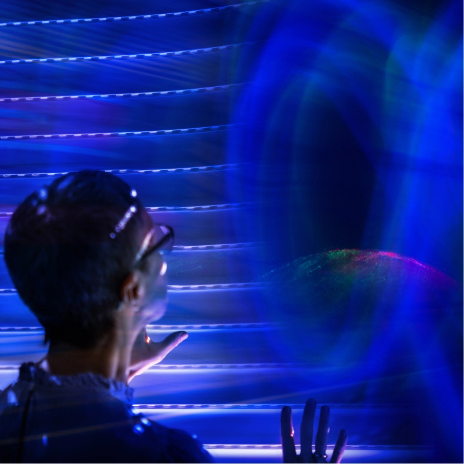 Two people standing by water with white panel